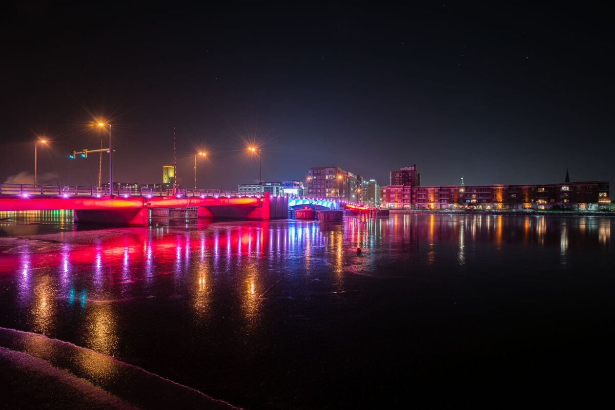 The Mason Street bridge lit up red and blue in downtown Green Bay, Wisconsin. The bridge is over the Fox River.