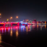 The Mason Street bridge lit up red and blue in downtown Green Bay, Wisconsin. The bridge is over the Fox River.
