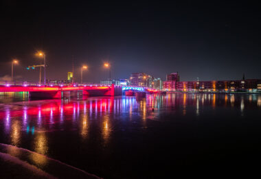 The Mason Street bridge lit up red and blue in downtown Green Bay, Wisconsin. The bridge is over the Fox River.