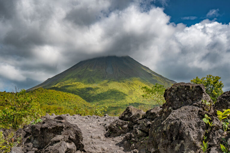 Arenal Volcano, Costa Rica 1 Arenal Volcano in Costa Rica, partially obscured by clouds, rises above lush green hills.