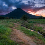 The sun sets behind the Arenal Volcano from La Fortuna in Costa Rica.
