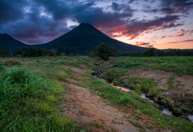 The sun sets behind the Arenal Volcano from La Fortuna in Costa Rica.