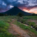 The sun sets behind the Arenal Volcano from La Fortuna in Costa Rica.