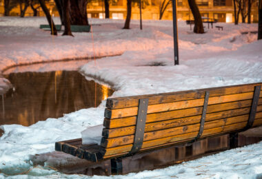 Snow surrounding a bench in Father Hennepin Bluff Park in Northeast Minneapolis.