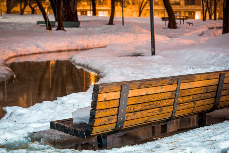 Bench in Father Hennepin Bluff Park 1 Snow surrounding a bench in Father Hennepin Bluff Park in Northeast Minneapolis.