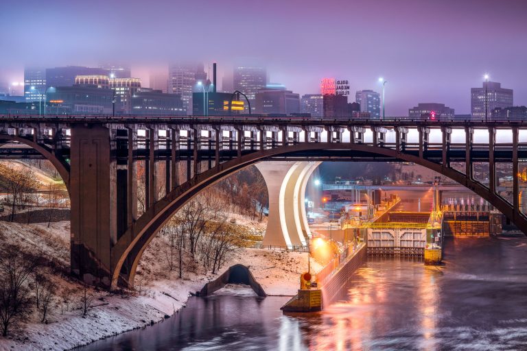 Gold Medal Flour Sign and Minneapolis Skyline, Mississippi River 1 Minneapolis Stone Arch Bridge spans the frozen Mississippi River at dusk with illuminated downtown skyline beyond.
