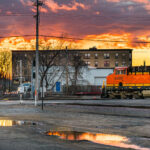 BNSF train goes through intersection at Harrison Sreet in Northeast Minneapolis during sunset.