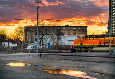 BNSF train goes through intersection at Harrison Sreet in Northeast Minneapolis during sunset.