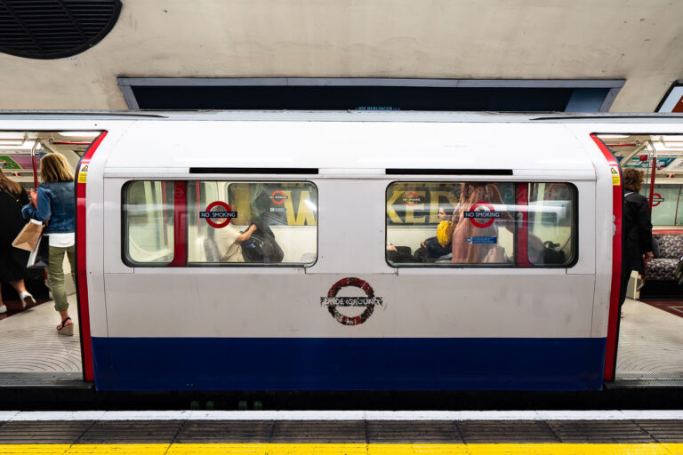 Charing Cross Underground — Bakerloo Line Platform 2 A Bakerloo Line train pauses at Charing Cross Underground Station, one of the most historically layered stations in central London. Opened in 1906, Charing Cross became a key interchange point connecting the Bakerloo and Northern lines beneath the Strand. The photograph captures the distinctive orange-tiled tunnel portal and overhead “Way Out” signage leading toward the mainline station above. Once part of the Jubilee Line until 1999, this section now serves as a terminus for Bakerloo trains, blending Edwardian design elements with the operational systems of a 21st-century network.