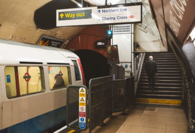 A Bakerloo Line train rests at Charing Cross Underground Station, beneath the heart of central London. Once a junction for both the Bakerloo and Jubilee lines, Charing Cross now functions as the southern terminus for Bakerloo services, connecting to the mainline station above. The photograph highlights the tunnel portal with its characteristic red tiles and the clean signage pointing toward the Northern line and the National Rail concourse. Opened in 1906 and expanded through the 1970s, the station remains an emblem of the Underground’s architectural layering—where Edwardian infrastructure meets modern transit demands.