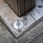 North Alignment Marker — London Street Survey Reference 4 A small directional survey marker embedded in a London pavement, used by city planners and cartographers for geospatial alignment. The engraved north arrow and circular design mark an official reference point in the city’s street network, often tied to Ordnance Survey data and modern GIS mapping systems. These subtle fixtures are essential for maintaining urban infrastructure accuracy, helping surveyors and engineers align roadworks, utilities, and property boundaries with London’s broader coordinate grid.