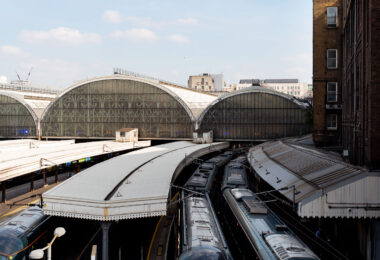 The trains at Paddington Station sit beneath the grand arched glass-and-iron roofs first designed by Isambard Kingdom Brunel and Matthew Digby Wyatt in the 1850s. The repeating barrel-vaulted structures—still marked by the faded “GWR” insignia for the Great Western Railway—remain a hallmark of Victorian railway engineering. Now serving modern intercity services such as the GWR and Heathrow Express, the station continues to blend historic design with contemporary rail operations, standing as one of London’s most architecturally significant transport hubs.