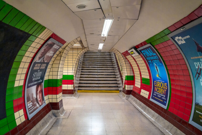 Piccadilly Circus Underground Passageway, London 1 An underground corridor at London’s Piccadilly Circus Station connects the Bakerloo and Piccadilly line platforms deep beneath central London. Opened in 1906, the station sits directly under the city’s busiest intersection and handles tens of millions of passengers each year. The tunnels were rebuilt in the 1920s to improve crowd circulation, creating a complex network of escalators and passages like this one that channel travelers toward exits under Shaftesbury Avenue and Regent Street. Despite its age, the station remains one of the Underground’s most recognizable and heavily trafficked transport hubs in the West End.