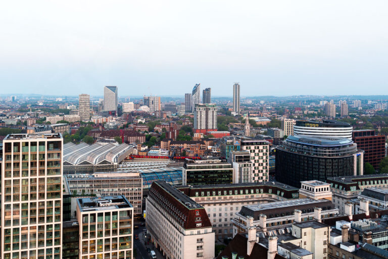 South Bank to Southwest London from the London Eye 1 Captured from one of the observation capsules of the London Eye, this elevated southwest-facing view looks across the South Bank and Waterloo Station toward the district of Vauxhall and the emerging skyline of Nine Elms and Battersea. The large curved glass roofs of Waterloo Station dominate the foreground, marking one of London’s busiest rail terminals. Beyond it, a mix of modern residential towers—including St George’s Wharf Tower and various recent high-rise developments—signal the transformation of South London’s riverfront. The image illustrates the urban evolution from historic masonry buildings near the Thames to new commercial and residential architecture further out, highlighting London’s shifting development landscape.
