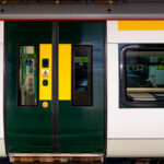 A close-up view of a Southern Railway Class 377 Electrostar unit, part of the modern suburban fleet serving routes across South London and the southern counties. The green and yellow livery, with sliding central doors and Wi-Fi signage visible through the window, reflects the operator’s current design standard for high-frequency commuter service. These electric multiple units, built by Bombardier, form the backbone of Southern’s network—efficiently linking London with Brighton, Gatwick, and the South Coast. The clean, modular profile emphasizes function and accessibility typical of post-2000 British rolling stock.