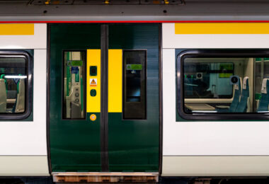 A close-up view of a Southern Railway Class 377 Electrostar unit, part of the modern suburban fleet serving routes across South London and the southern counties. The green and yellow livery, with sliding central doors and Wi-Fi signage visible through the window, reflects the operator’s current design standard for high-frequency commuter service. These electric multiple units, built by Bombardier, form the backbone of Southern’s network—efficiently linking London with Brighton, Gatwick, and the South Coast. The clean, modular profile emphasizes function and accessibility typical of post-2000 British rolling stock.