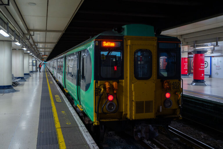Southern Class 455 at London Victoria 1 A Southern Railway Class 455 electric multiple unit prepares to depart from London Victoria station on a suburban service bound for Sutton. These 1980s-era trains, built by British Rail Engineering Limited, have long served the dense commuter corridors of South London and Surrey. The terminal’s subterranean platforms, seen here beneath the main concourse, handle both Gatwick Express and local Southern services, linking central London with its southern suburbs through one of the busiest rail hubs in Britain.