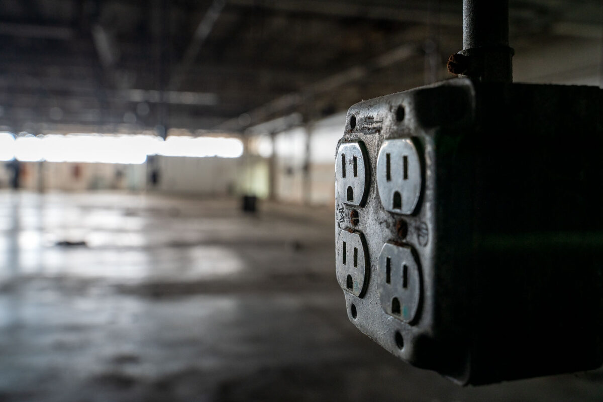 An electrical outlet inside an empty warehouse.