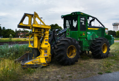 A John Deere 843L feller buncher sits parked near the railway tracks in St. Louis Park, Minnesota, during the early stages of construction for the Southwest Light Rail Transit (LRT) project. Designed primarily for forestry work, this heavy-duty machine—with its massive front grapple and thick treaded tires—was adapted for clearing brush and trees along the rail corridor. The mix of heavy equipment, rail infrastructure, and suburban backdrop highlights the region’s ongoing transformation as the light rail expansion reshapes Minneapolis’s western suburbs.