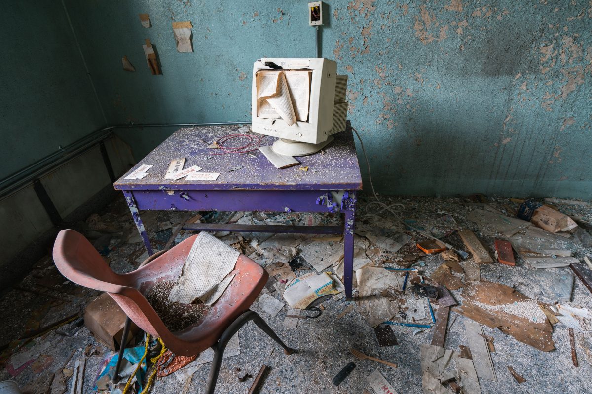 Abandoned room at Creedmore Psychiatric Center in Queens, New York, with a discarded television and deteriorated furniture.