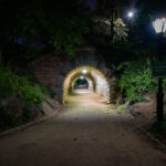 The Inscope Arch sits near the southeast corner of Central Park, close to Grand Army Plaza and 59th Street. At night, the stone passageway offers a calm, almost hidden route beneath the park’s trees.