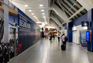 Travelers walk past a construction wall at LaGuardia Airport in Queens, New York, on Sunday, Sept. 14, 2025. Renovations continue at the Delta terminal as part of the airport’s multibillion-dollar redevelopment project.