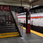 A staircase leads to the exit at the 47–50 Streets Rockefeller Center subway station in Manhattan. The station serves the B, D, F, and M lines.