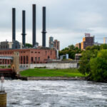 The Southeast Steam Plant, with its four iconic smokestacks, rises over the Mississippi River near the University of Minnesota’s East Bank campus. Once a coal-fired power station, the facility has been adapted into a cleaner-burning natural gas plant, continuing its role as a landmark in Minneapolis’s industrial skyline.