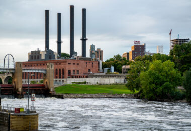 The Southeast Steam Plant, with its four iconic smokestacks, rises over the Mississippi River near the University of Minnesota’s East Bank campus. Once a coal-fired power station, the facility has been adapted into a cleaner-burning natural gas plant, continuing its role as a landmark in Minneapolis’s industrial skyline.