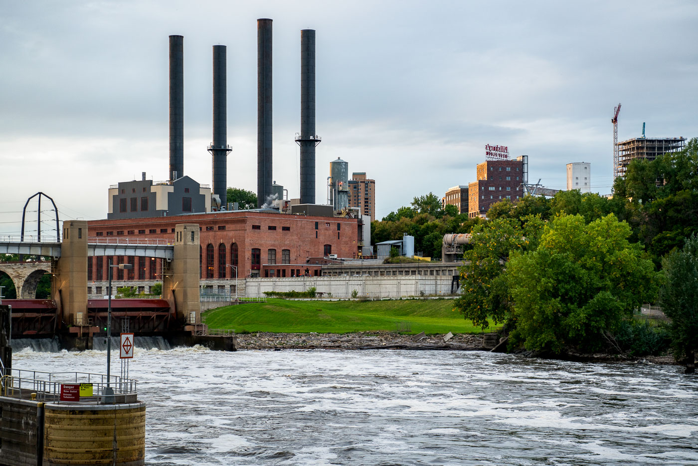 The Southeast Steam Plant, with its four iconic smokestacks, rises over the Mississippi River near the University of Minnesota’s East Bank campus. Once a coal-fired power station, the facility has been adapted into a cleaner-burning natural gas plant, continuing its role as a landmark in Minneapolis’s industrial skyline.