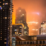A foggy night in downtown Minneapolis with IDS Center in the background with Xcel Energy Headquarters in the foreground.