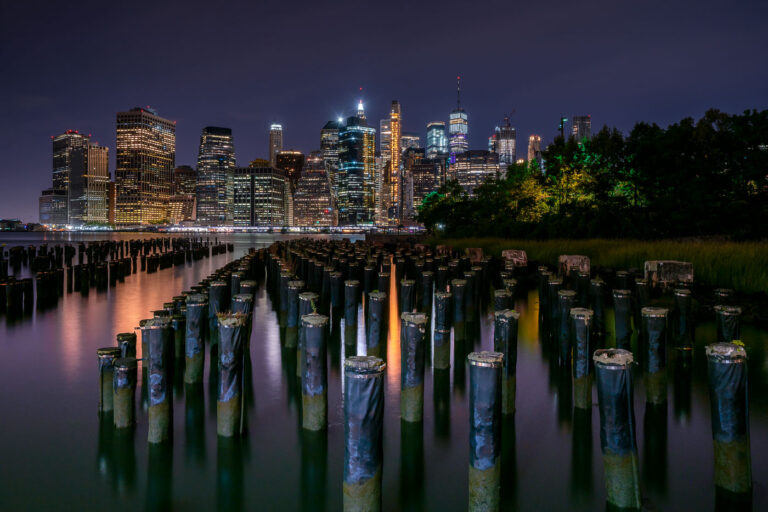 Wood Pilings at Brooklyn Bridge Park in New York 3 Old wooden pilings rise from the East River with the Manhattan skyline glowing in the background. Viewed from Brooklyn Bridge Park