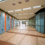 An empty corridor of the Chicago Pedway connects the Randolph/Washington subway station to surrounding office buildings and shopping centers beneath the Loop. The Pedway system, developed beginning in the 1950s, extends for more than 40 city blocks, linking major transit lines with civic and commercial spaces. Its mid-century design—terrazzo floors, tiled walls, and fluorescent lighting—reflects the city’s practical approach to all-weather pedestrian infrastructure, a defining feature of downtown Chicago’s urban core.