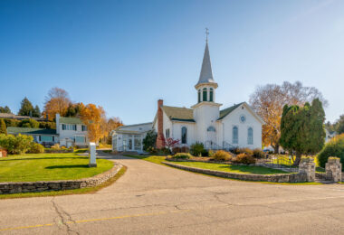 The Ephraim Moravian Church, located in the heart of Ephraim, Wisconsin, dates back to the mid-19th century and reflects the town’s deep Moravian heritage. Founded in 1853 by Norwegian settlers under the leadership of Reverend Andreas Iverson, the congregation built this white clapboard church overlooking Eagle Harbor as both a house of worship and a symbol of unity for the early Door County community. The building’s steeple, traditional in form yet understated in design, continues to define Ephraim’s skyline, linking the village’s modern charm with its Scandinavian and religious roots.