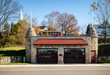The historic Ephraim Volunteer Fire Department Museum, housed in a stone building with classic red doors, stands as a reminder of small-town service and heritage in Ephraim, Wisconsin.