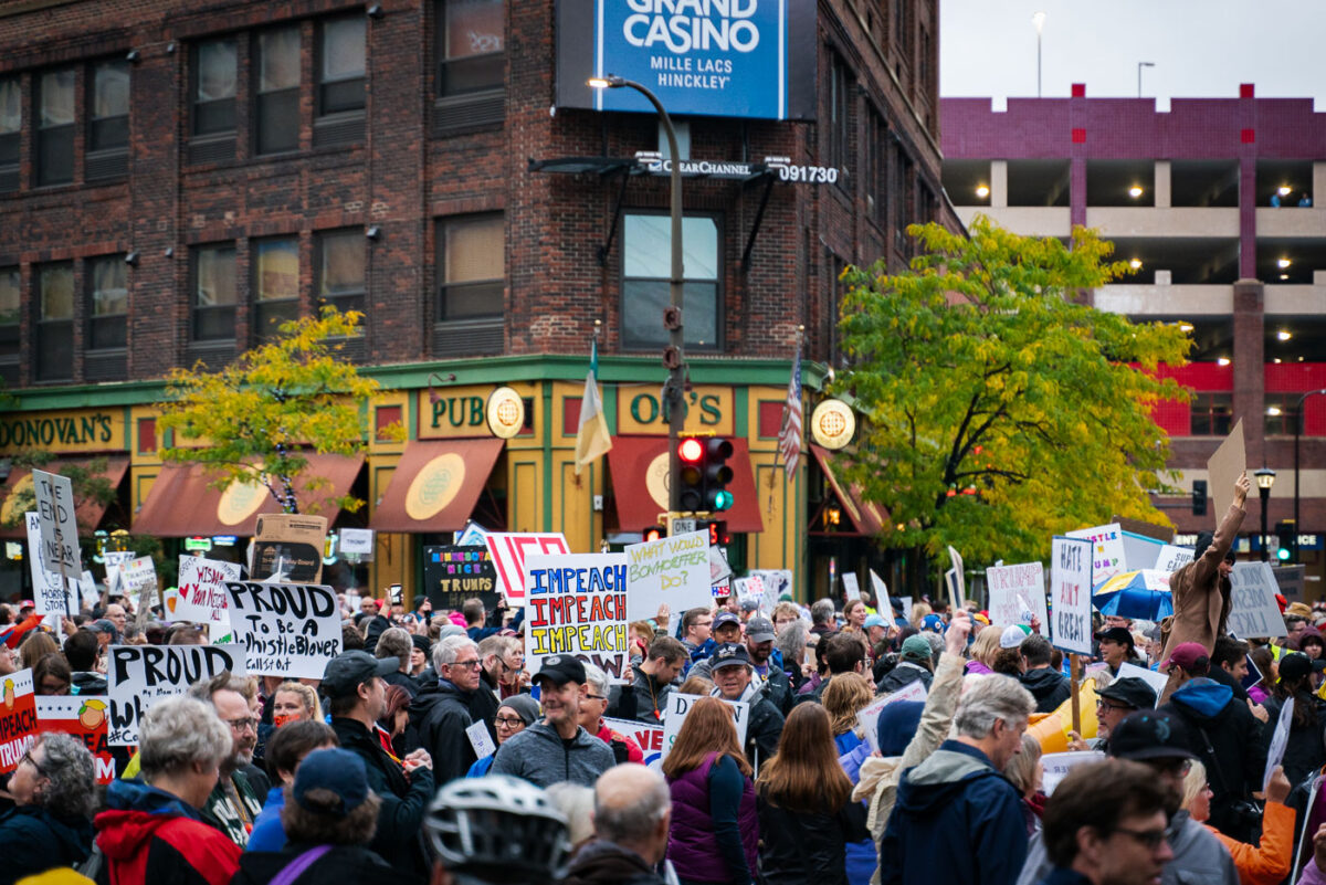 Protestors hold up signs outside the Target Center during a Trump protest in Minneapolis on October 10, 2019.