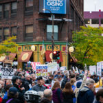Protesters hold up signs outside the Target Center during a Trump protest in Minneapolis on October 10, 2019.