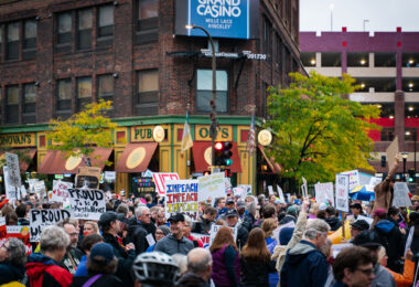 Protesters hold up signs outside the Target Center during a Trump protest in Minneapolis on October 10, 2019.
