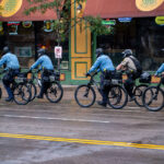 Police on bicycles patrol downtown Minneapolis outside the Target Center while protesters and rally-goers gather ahead of a 2019 Trump campaign event.