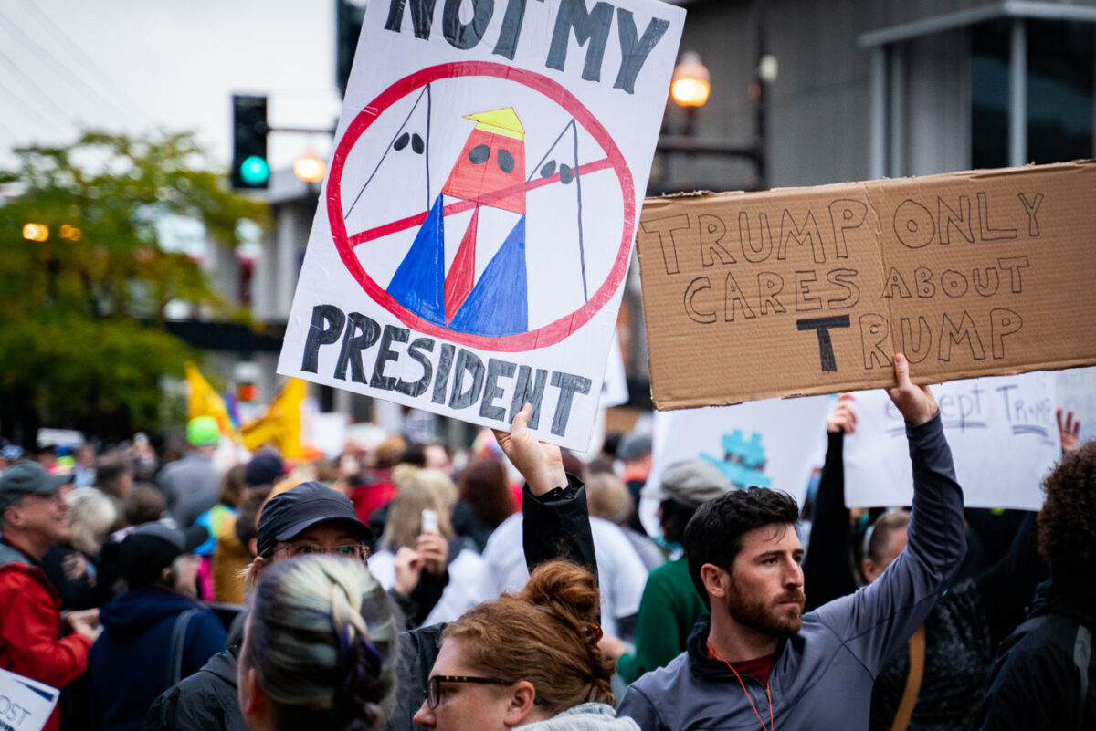 Protesers hold up signs outside the Target Center in Minneapolis on October 10, 2019.