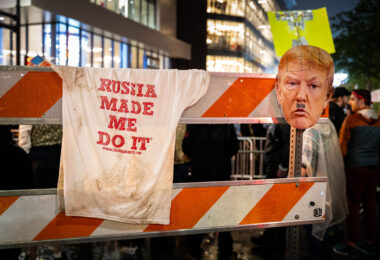 A barricade outside the Target Center in downtown Minneapolis displays a T-shirt reading “Russia Made Me Do It” and a defaced cutout of Donald Trump’s face during protests on October 10, 2019. The demonstration coincided with Trump’s campaign rally at the arena, his first visit to Minnesota since the release of the Mueller report. Thousands of protesters gathered in the streets of the Warehouse District, voicing opposition to the president’s rhetoric and policies amid a heavy police presence and national media attention.