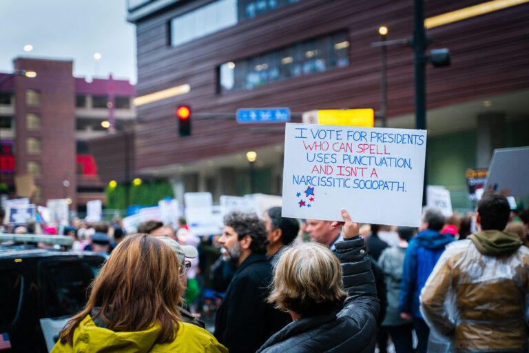 Minneapolis Trump Rally on October 10, 2019 1 Man holds up a sign that reads "I vote for presidents who can spell, uses punctuation and isn't a narcissistic sociopath." outside the Target Center during a Trump protest on October 10, 2019.