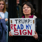Woman holds up a sign that reads "Trump read my sign" in Minneapolis on October 10, 2019.