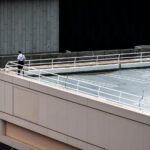 A security officer surveys the area from a parking ramp rooftop across from the Target Center in downtown Minneapolis on October 10, 2019. The elevated position provided an unobstructed view of streets surrounding the arena ahead of a campaign rally held by President Donald Trump. Local police, federal agents, and Homeland Security personnel maintained a visible presence throughout the entertainment district as thousands of attendees and protesters gathered nearby.