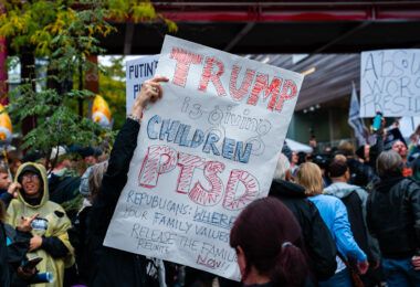 A protester holds up protest sign outside the Target Center in Downtown Minneapolis where Trump was to speak in October 2019.