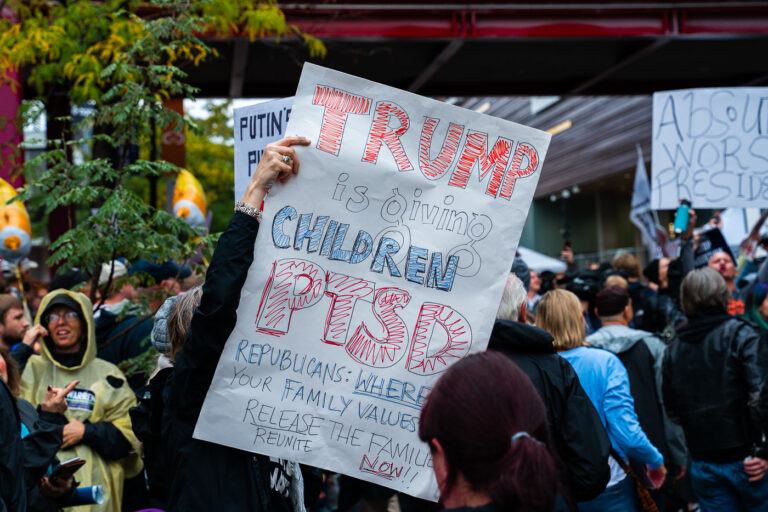 Protest sign at Minneapolis Trump Rally 1 A protester holds up protest sign outside the Target Center in Downtown Minneapolis where Trump was to speak in October 2019.