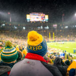 A fan wears a knit Packers hat at a snowy Lambeau Field as the Packers work to defeat the Carolina Panthers 24-16.