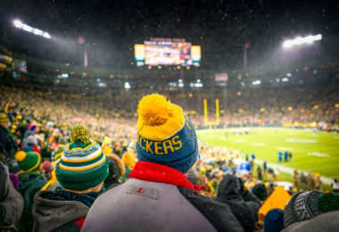 A fan wears a knit Packers hat at a snowy Lambeau Field as the Packers work to defeat the Carolina Panthers 24-16.