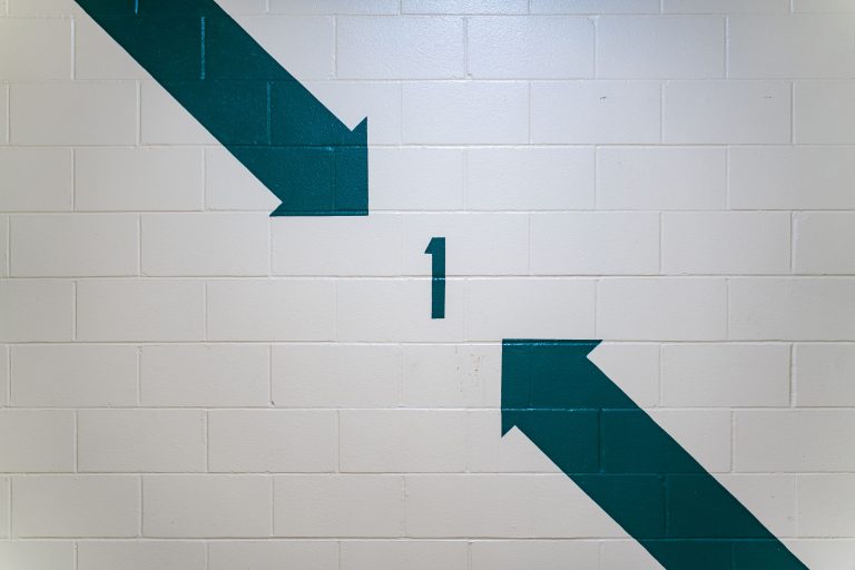 Level 1 Directional Arrows, Parking Garage, Minneapolis 1 Teal arrows and the number 1 painted on a concrete block wall in a Minneapolis parking garage.