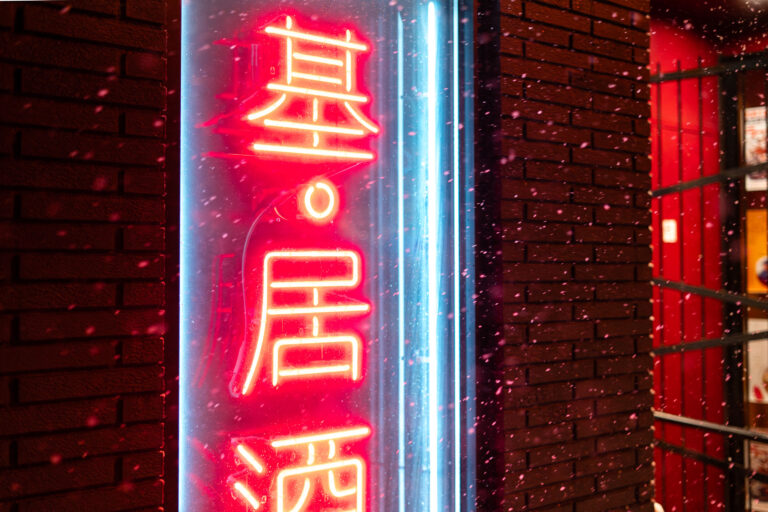 Moto-i Neon Sign in Snow, Uptown Minneapolis 1 Moto-i neon sign in snow on Lyndale Avenue in Minneapolis, lit against a brick wall.